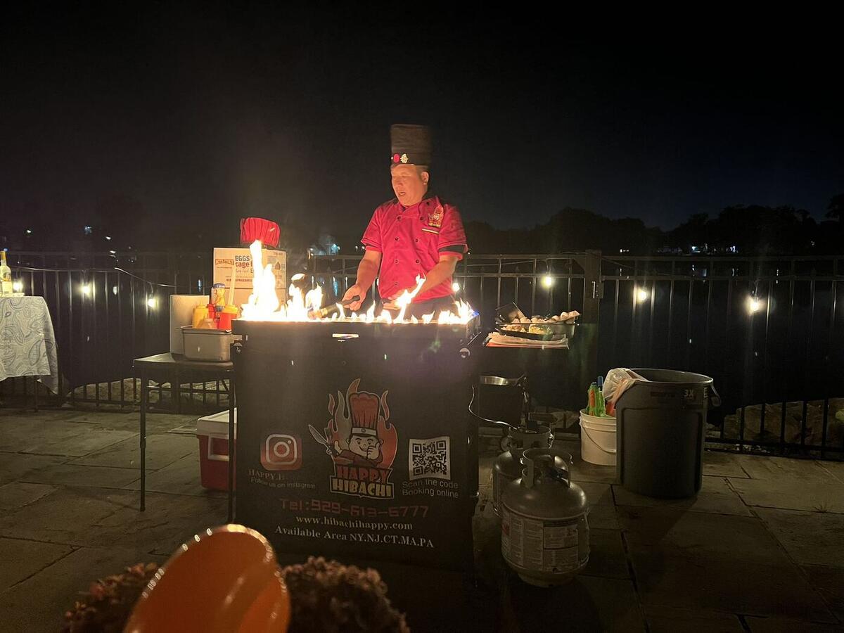 Hibachi chef cooking at a nighttime waterfront party in Connecticut